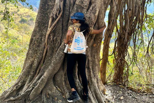 Yoga retreat student huging tree in rishikesh