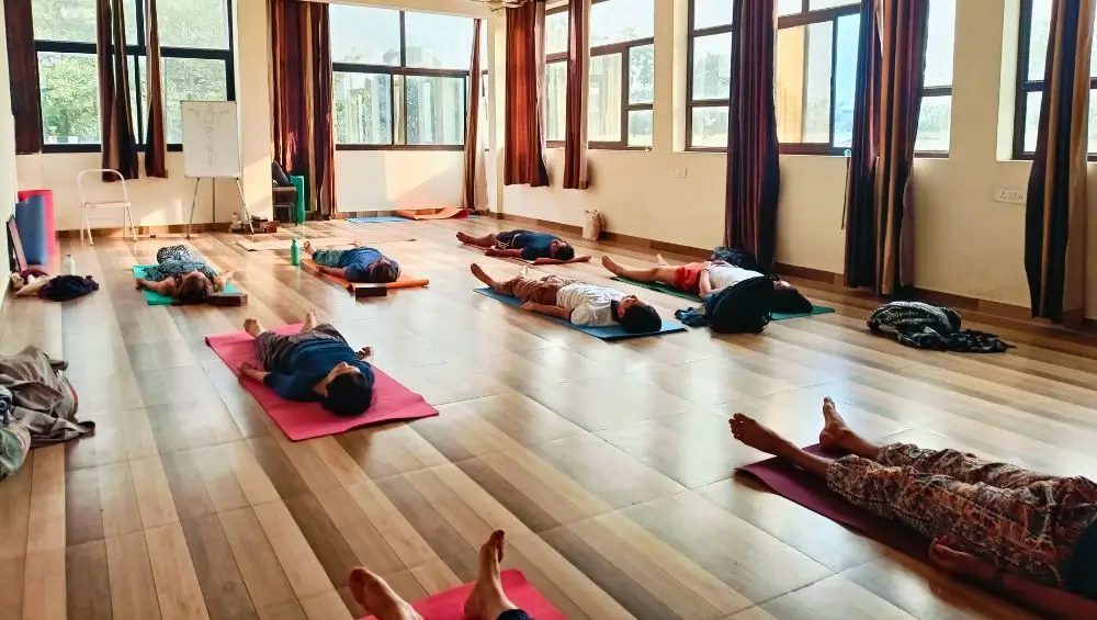 Yoga Teacher Training Course Students doing Savasana in Yoga Hall of Rishikesh Yoga Valley School