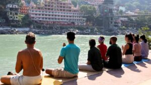 meditation during sunrise near ganga river rishikesh