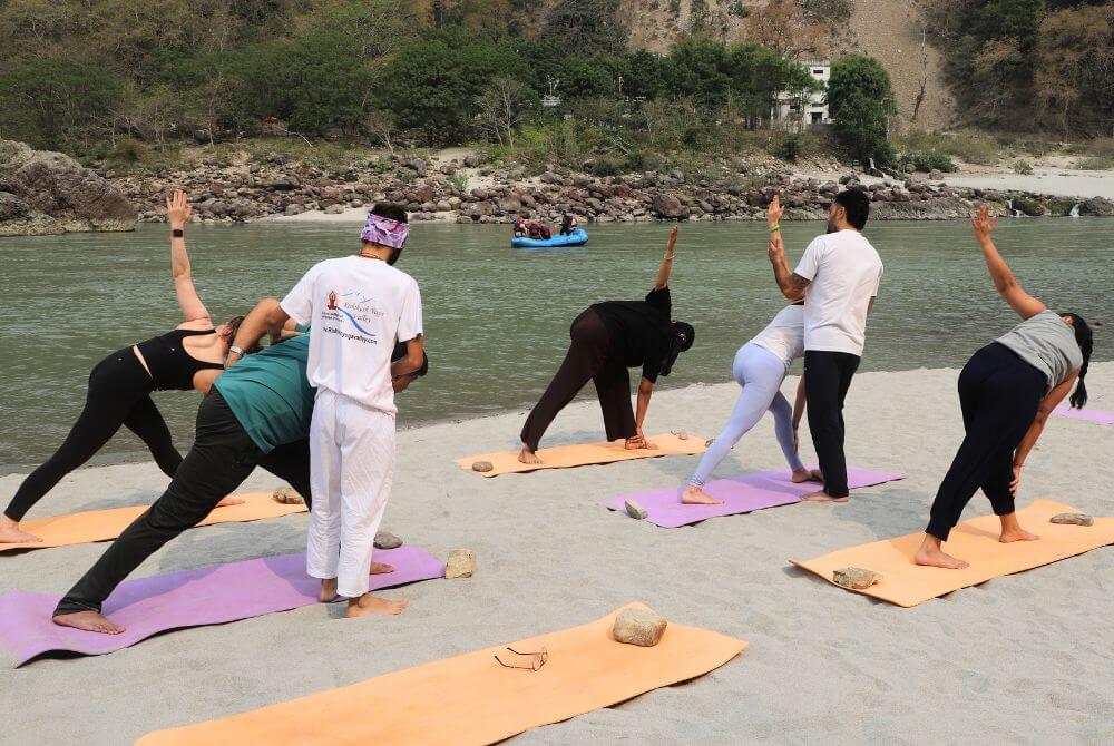 Yoga Teacher Kamal Negi adjusting alignment of yoga pose