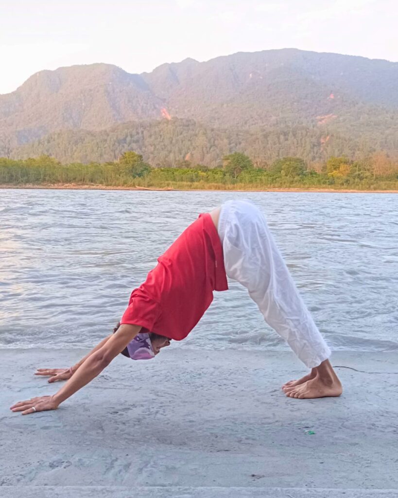 A person in Parvatasana or Mountain Pose, forming an inverted V with hands and feet grounded and hips lifted high during Surya Namaskar.