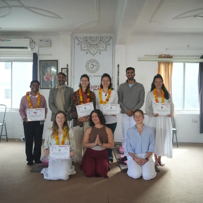 Group of diverse students holding certificates after completing their Sound Healing Training Course in a yoga studio setting.