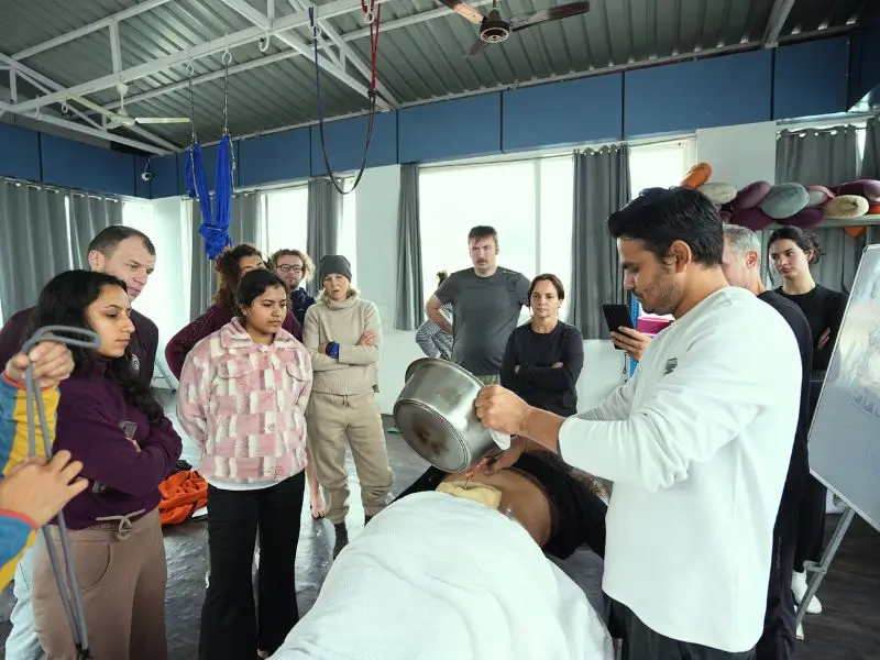 ayurvedic therapy demonstration during 10 days ayurveda and yoga retreat in rishikesh india with students observing treatment