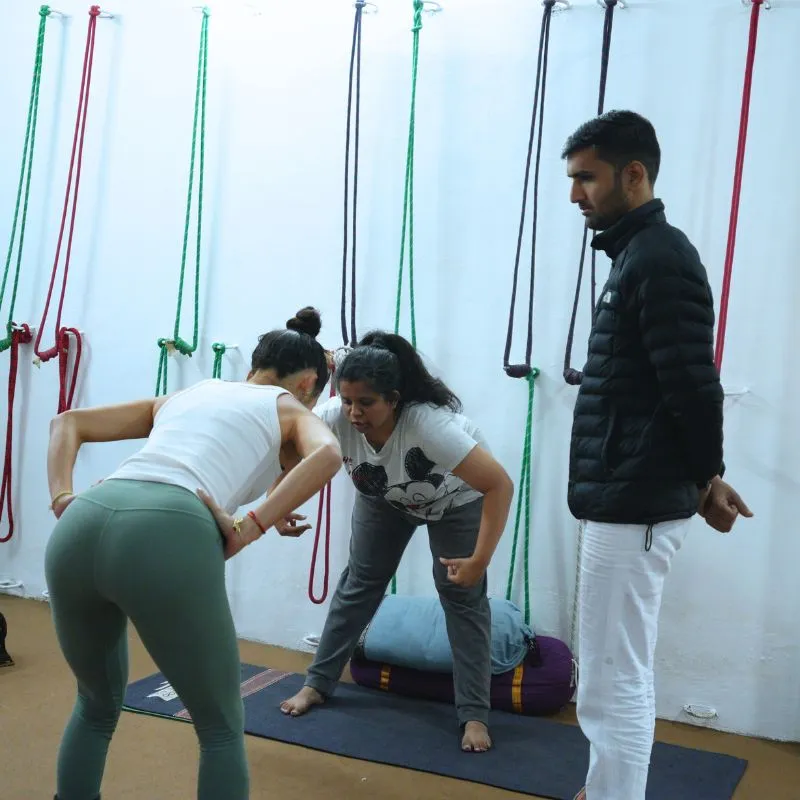 Yoga Teacher teaching yoga asana pose during their 100 hour yoga teacher training in rishikesh at rishikesh yoga valley