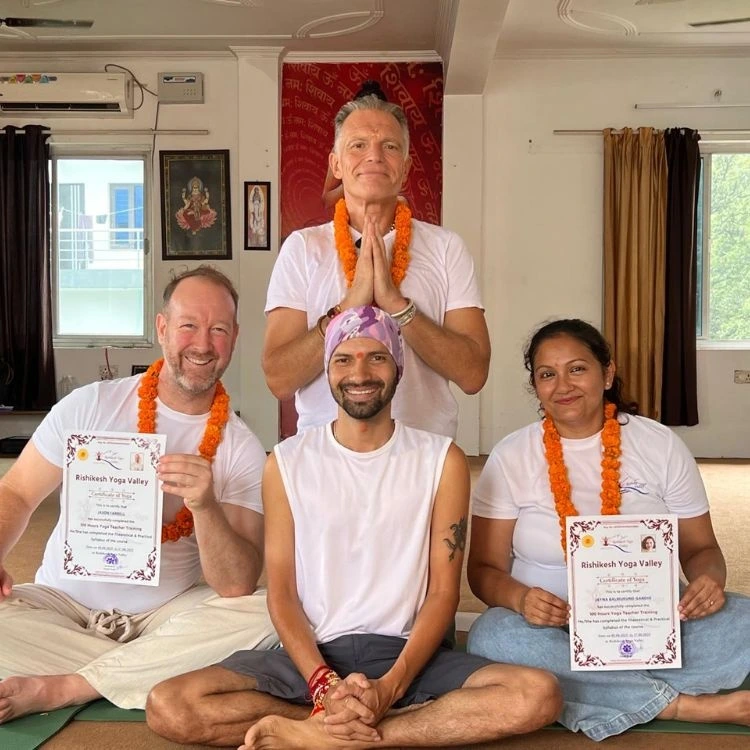 Students holding certificates after completing 200 hour yoga teacher training in Rishikesh, India.