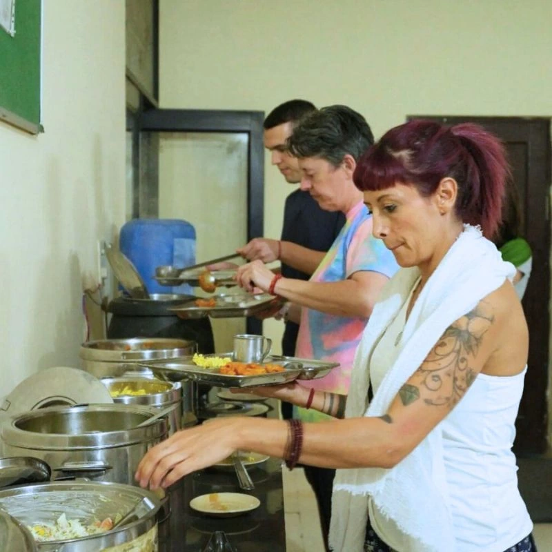 Students serving healthy sattvic vegetarian food during 50 hour yoga teacher training in Rishikesh, India.