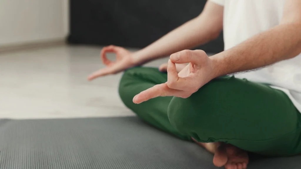 Student practicing meditation during yoga teacher training while learning proper mindfulness techniques.