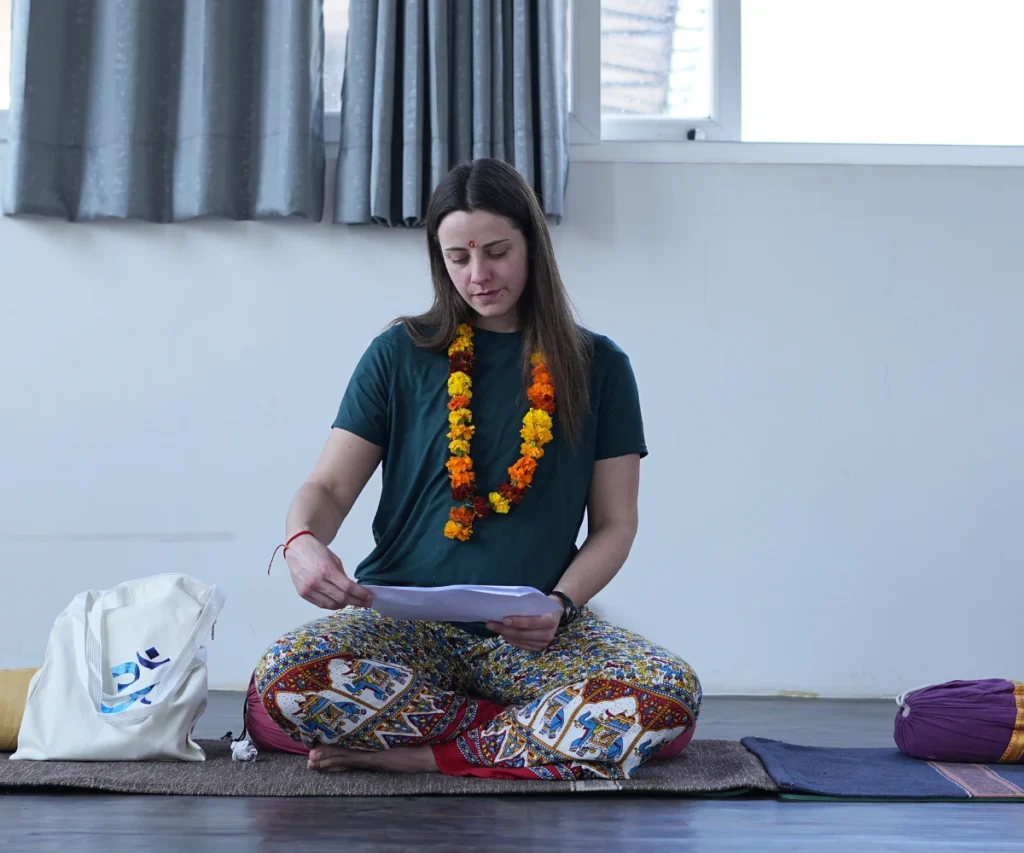 Student reading yoga teacher training pages during yoga TTC