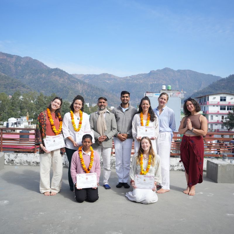 Students wearing traditional marigold garlands during a cultural ceremony at an aerial yoga teacher training course in Rishikesh, India.