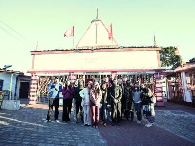 A large group of international students standing together in front of a traditional Hindu temple during an Ayurveda retreat in Rishikesh.