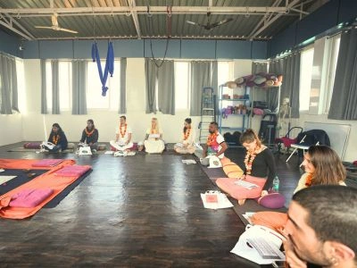Students sitting in a circle on yoga mats during an educational theory session at one of the top Ayurveda retreats in Rishikesh.