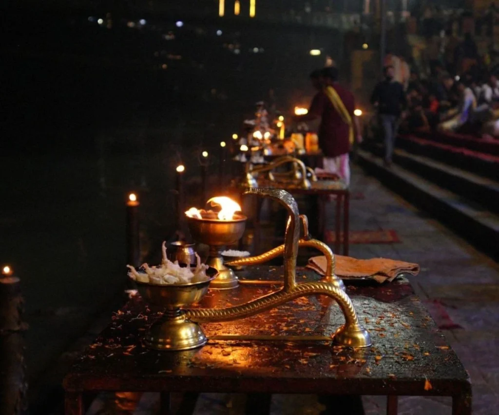 Traditional Ganga Aarti ritual with oil lamps on the banks of the Ganges river in Rishikesh, India.