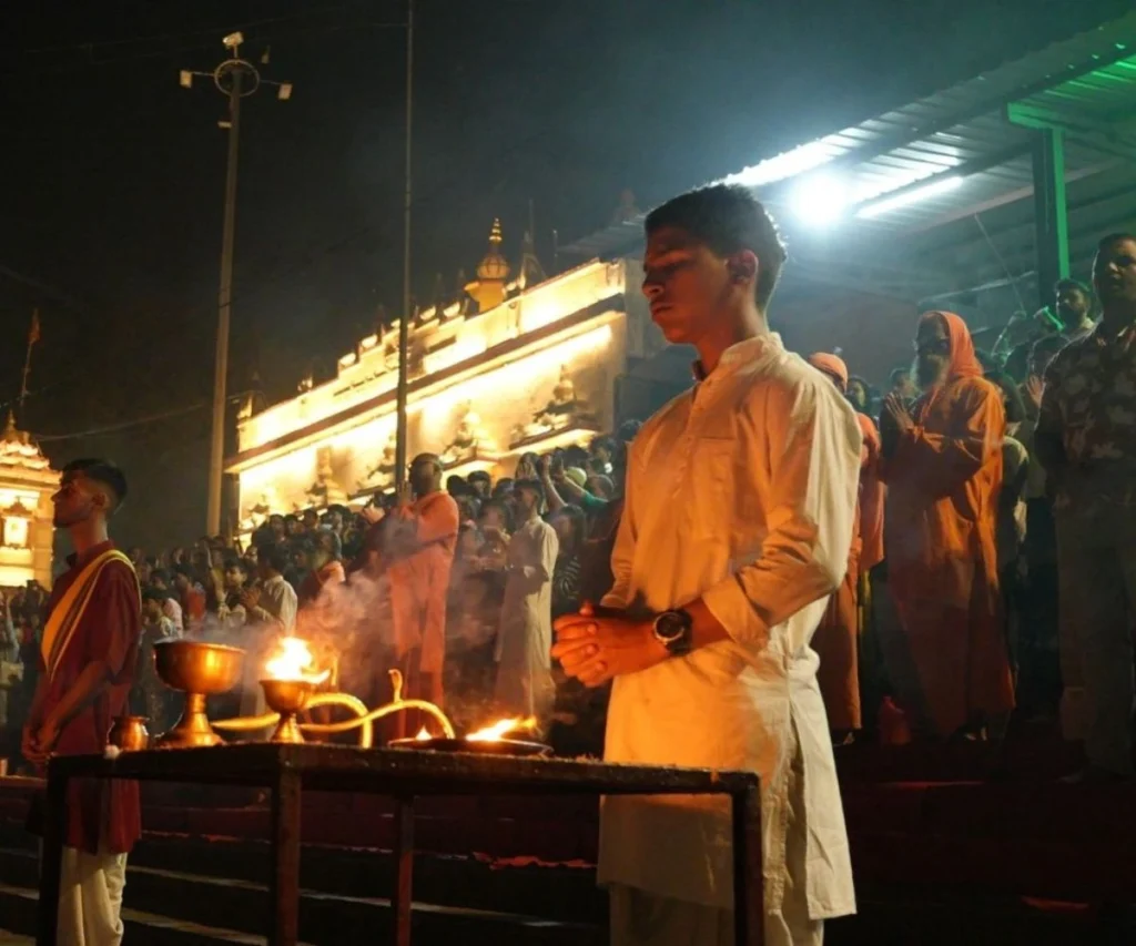 Student attending Ganga Aarti ceremony during yoga teacher training in Rishikesh, India.
