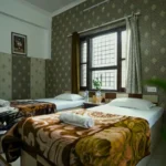 Twin sharing accommodation room for yoga teacher training students in Rishikesh India with attached bathroom and window view