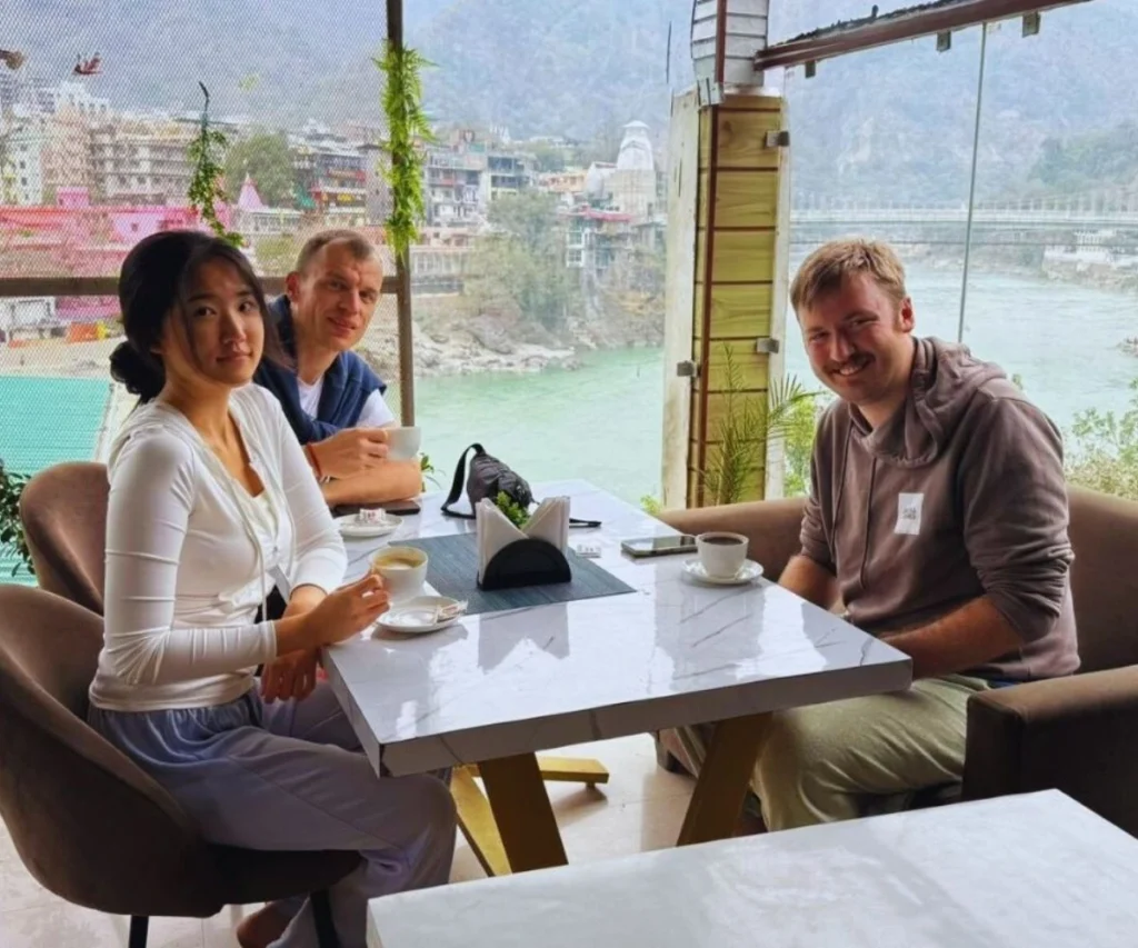 Yoga teacher training students enjoying tea with a view of the Ganga river in Rishikesh, India.