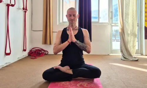 Student practicing meditation during 50 hour yoga teacher training in Rishikesh India inside a traditional yoga studio
