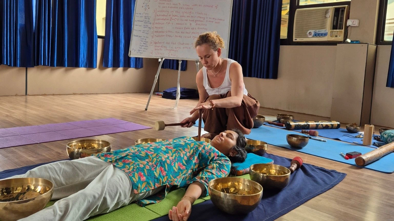 Sound healing therapy session with Tibetan singing bowls during yoga meditation practice for deep relaxation, chakra balancing, mindfulness, and holistic wellness