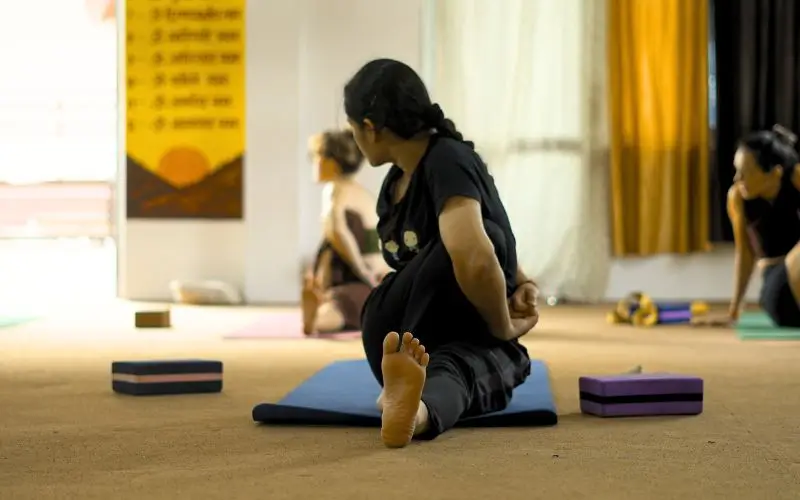 Student practicing a seated spinal twist yoga pose during a 100 Hour Yoga Teacher Training in Rishikesh India at Rishikesh Yoga Valley, focusing on flexibility, alignment, and mindful movement.