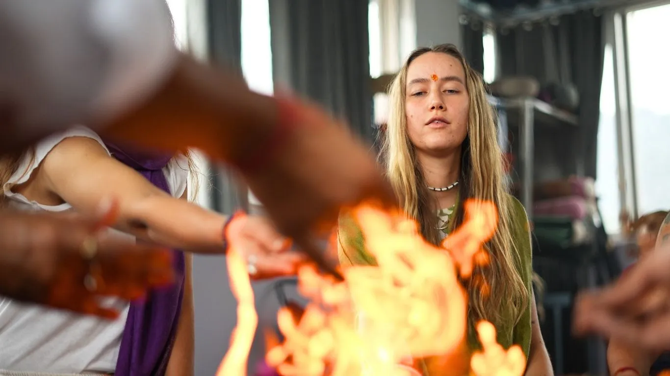 Student participating in a traditional fire meditation ceremony during a 200 hour Kundalini Yoga Teacher Training in Rishikesh India.