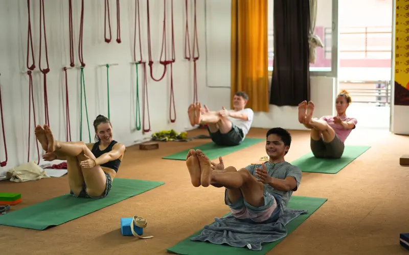 Students practicing core-strengthening yoga asanas during a 500 hour Yoga Teacher Training in Rishikesh India.