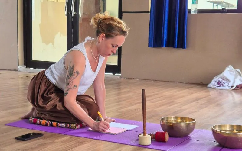 Participant documenting insights after a sound healing session during a sound healing course in Rishikesh.