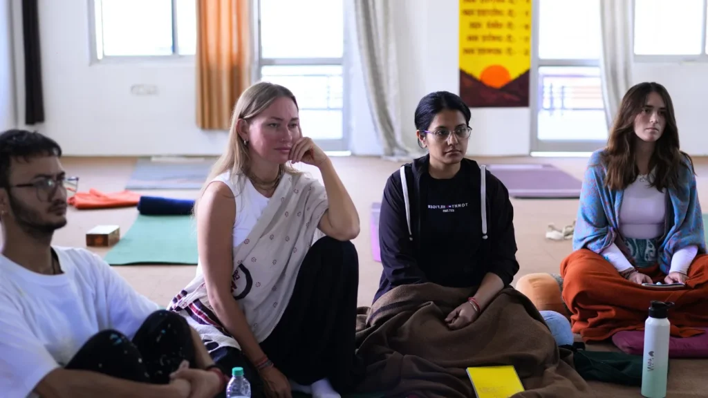 Students listening intently in a lecture, wondering how difficult is 200 hour yoga teacher training