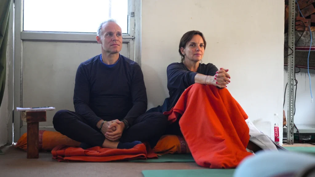 A man and woman sitting cross-legged during a yoga philosophy theory class, illustrating whether a 200-hour yoga teacher training is worth it in this honest guide.