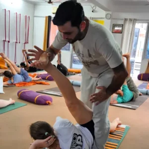 Rohit Kamboj assisting a student with Hatha Yoga alignment during a 10 Days Yoga Retreat in Rishikesh