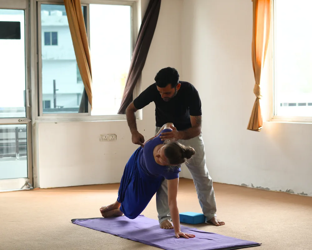 Yoga teacher assisting a participant with alignment during a 10 Days Yoga Retreat in Rishikesh