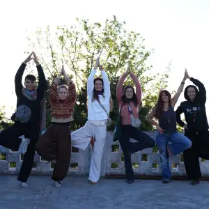 Group of yoga students practicing tree pose together outdoors during a 100 hour yoga teacher training in Rishikesh