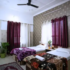 Spacious twin-sharing accommodation room with clean bedding and modern amenities for students enrolled in the 300 hour yoga teacher training in rishikesh.