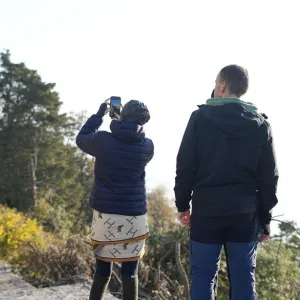 Two yoga students standing outdoors taking photos of Himalayan nature with a smartphone during an excursion in the 50 hour yoga teacher training in rishikesh.