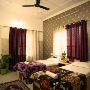 Twin-sharing student accommodation room with single beds, clean linens, and amenities at the aerial yoga teacher training in Rishikesh.