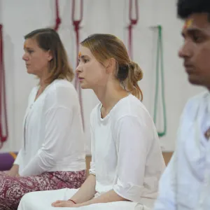 Students meditating in white attire during a sound healing course in Rishikesh
