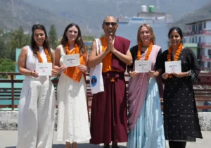Yoga students holding their certificates after completing a Yoga Alliance certified teacher training program