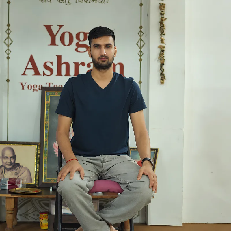 Neeraj Rayal seated in a meditation posture at a yoga training school in Rishikesh, India
